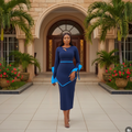 Nigerian female model wearing navy blue long sleeve midi dress with electric blue contrast trim in upscale Nigerian residential compound