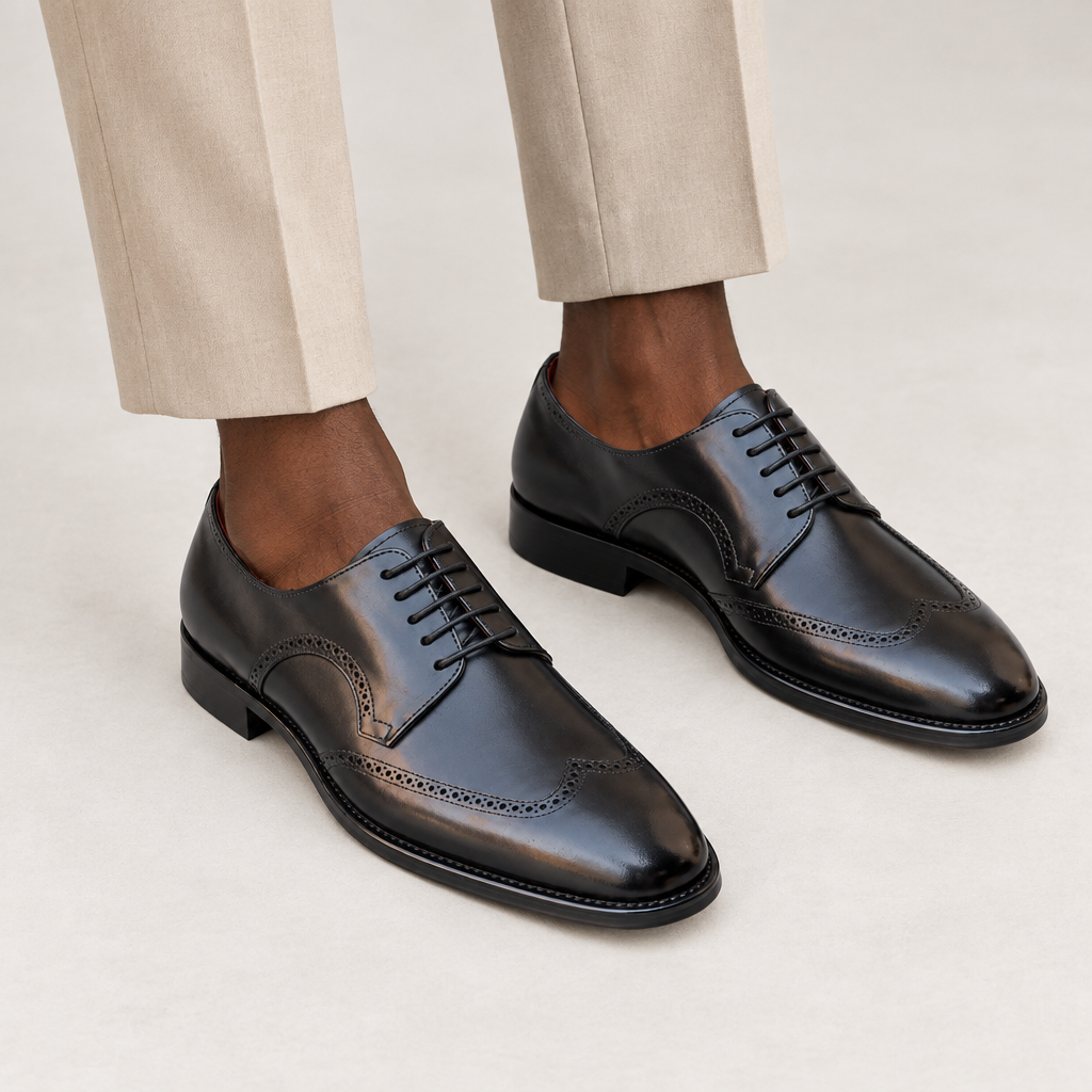 Black lace-up wingtip shoes worn with beige trousers