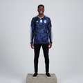 Nigerian male model wearing black blue baroque long sleeve football jersey on concrete plinth