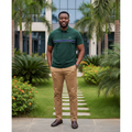 Nigerian male model wearing men's forest green polo shirt with chest stripe, garden setting