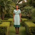 Nigerian teenage girl model wearing mint green pleated midi dress with floral appliqué