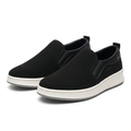 Matching pair of black textured slip-on shoes with off-white soles on white