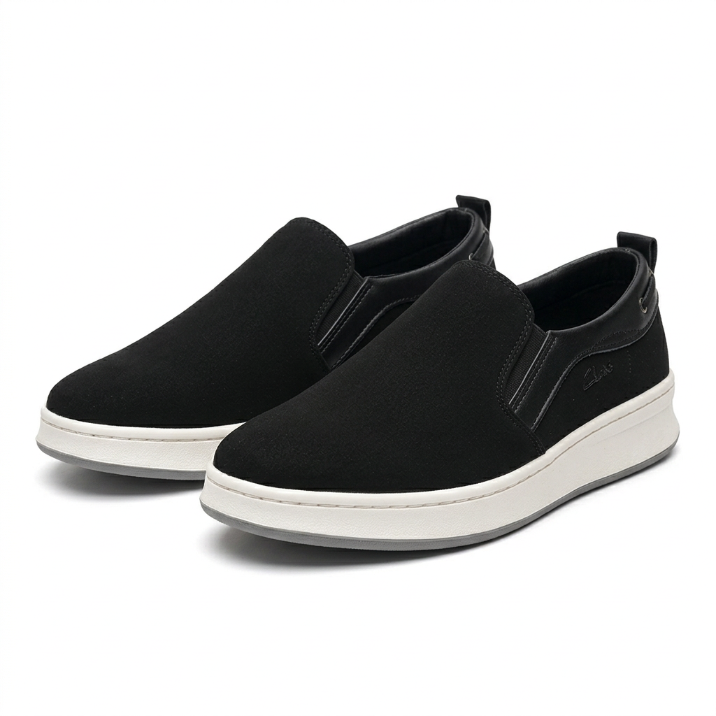 Matching pair of black textured slip-on shoes with off-white soles on white