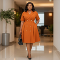 Nigerian woman wearing orange double-breasted midi shirt dress in upscale setting