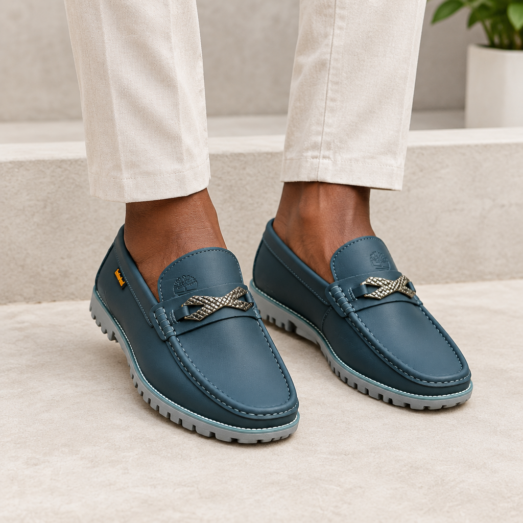 Black model wearing slate blue men's slip-on loafers with woven detail