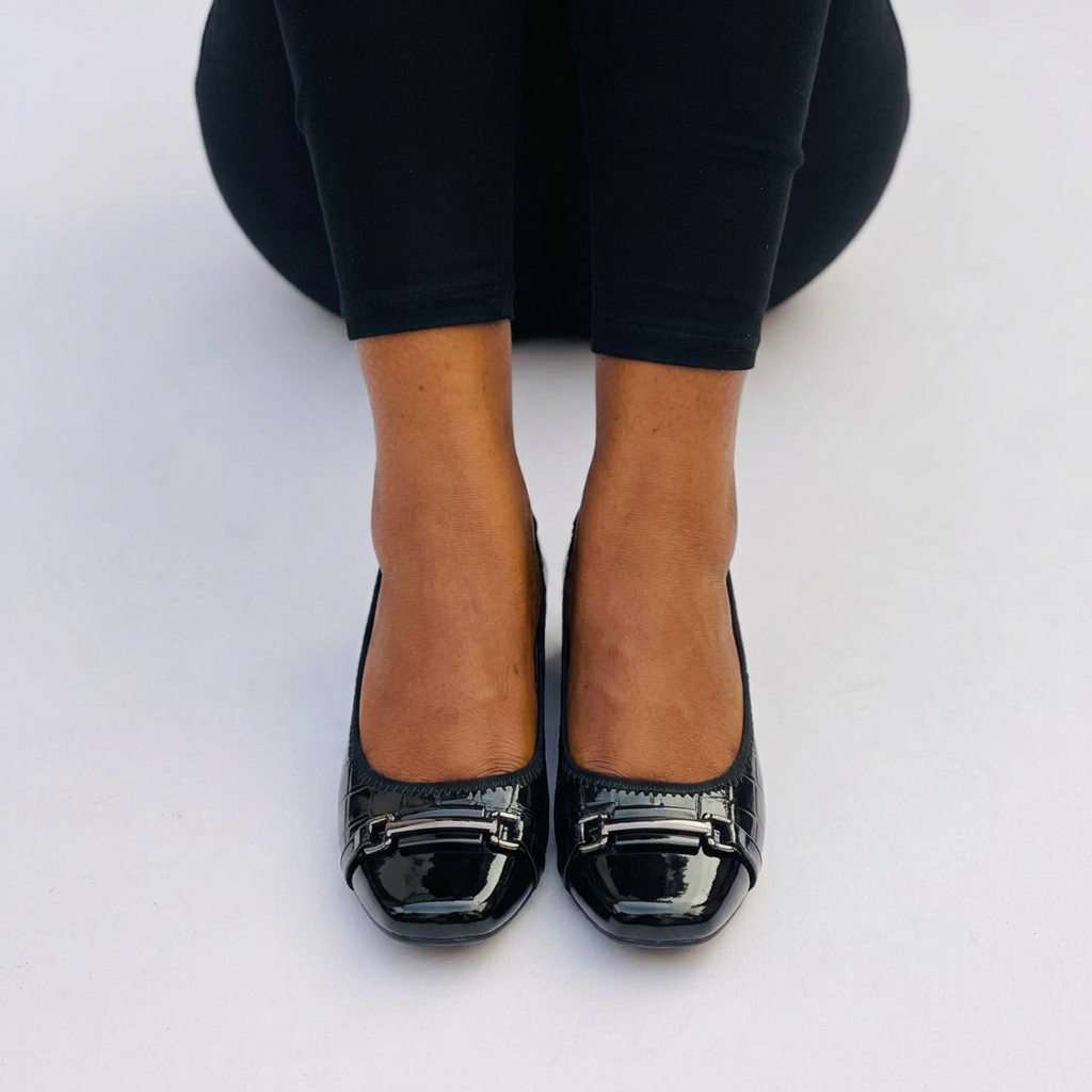 Adult woman wearing black bar-detail wedges with feet together