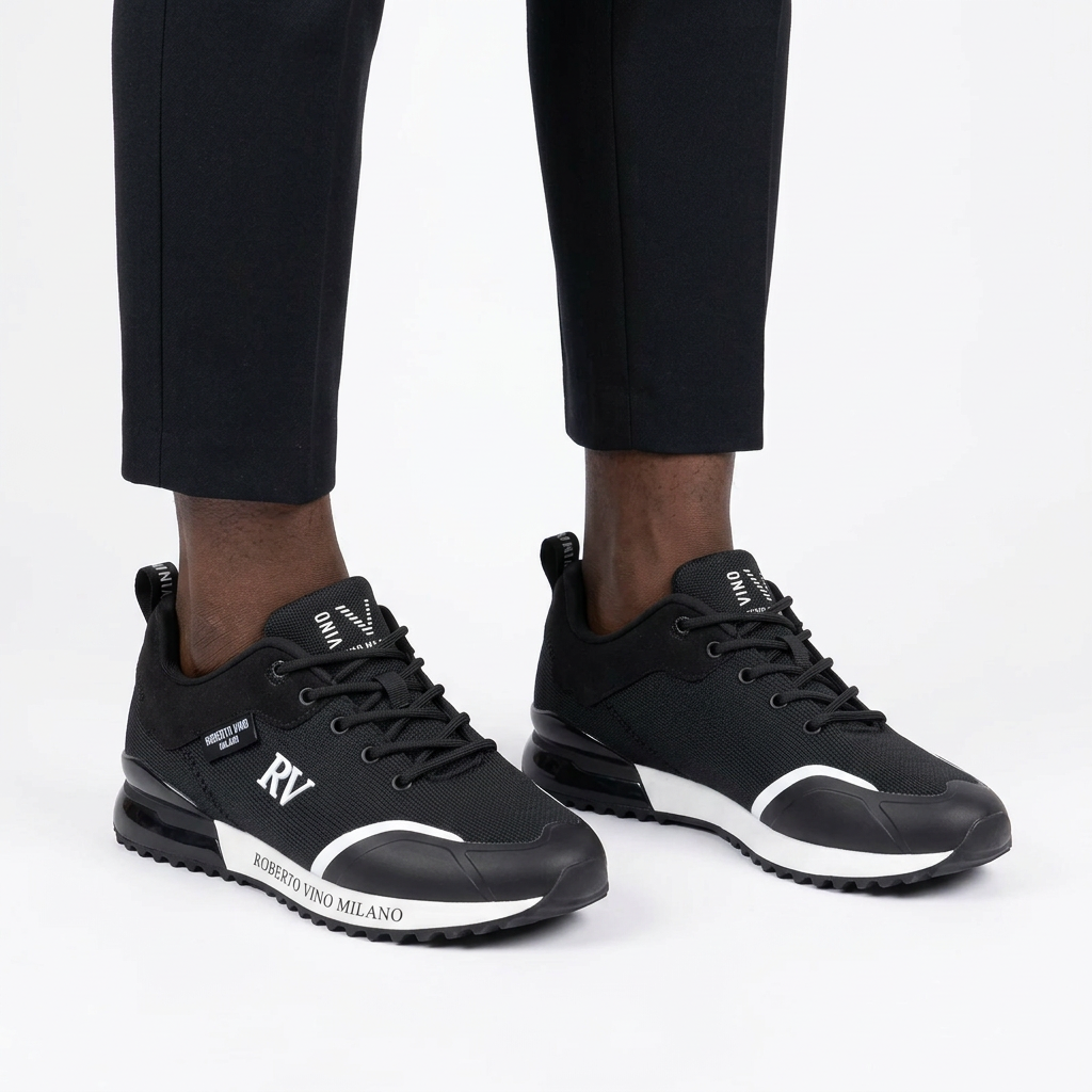 Charcoal mesh contrast-trim sneakers worn on both feet by a Black male model on a white studio background