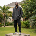 Nigerian male model wearing charcoal striped oversized embroidered long-sleeve shirt – full body lifestyle shot