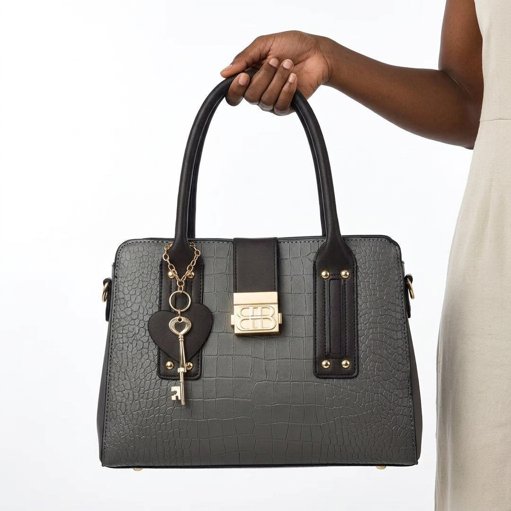 Grey embossed tote with black trim held by one hand gripping both handles