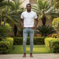 Adult Nigerian male model wearing light wash slim denim jeans in garden setting