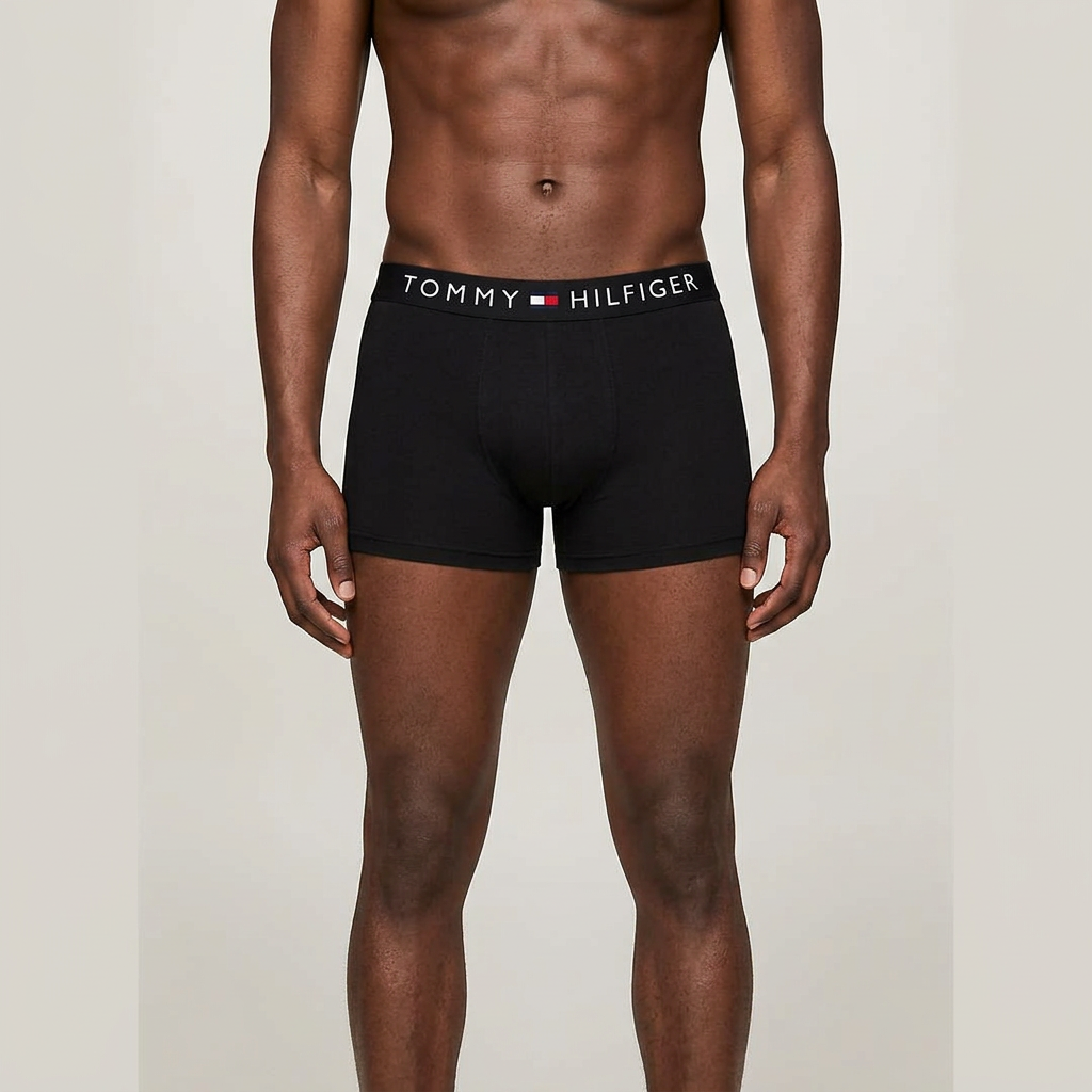 Male model wearing only black boxer briefs in one plain studio frame