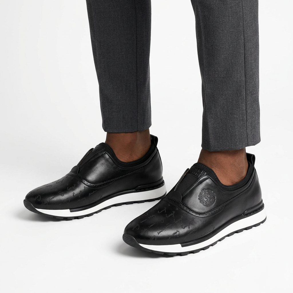 Both black patterned slip-on shoes worn with charcoal trousers