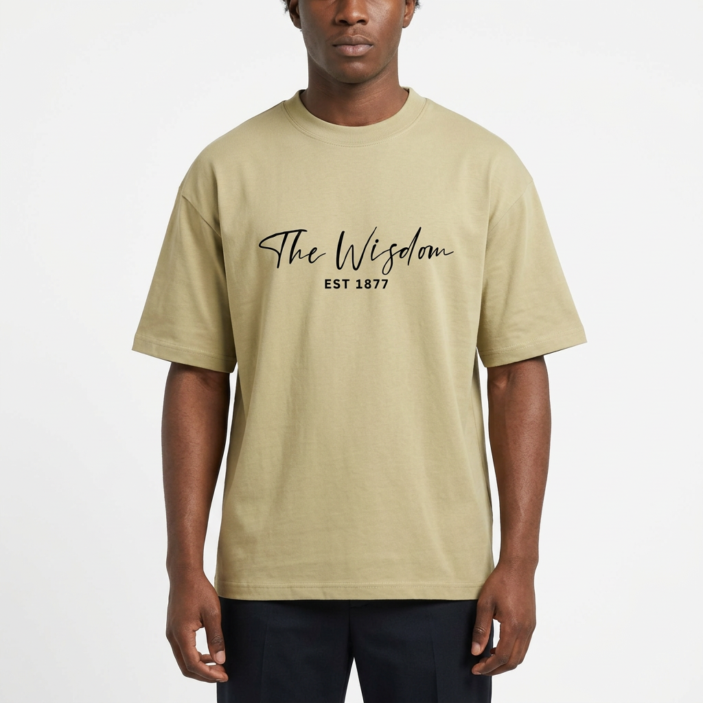 Nigerian male model wearing a light olive T-shirt with The Wisdom EST 1877 chest artwork
