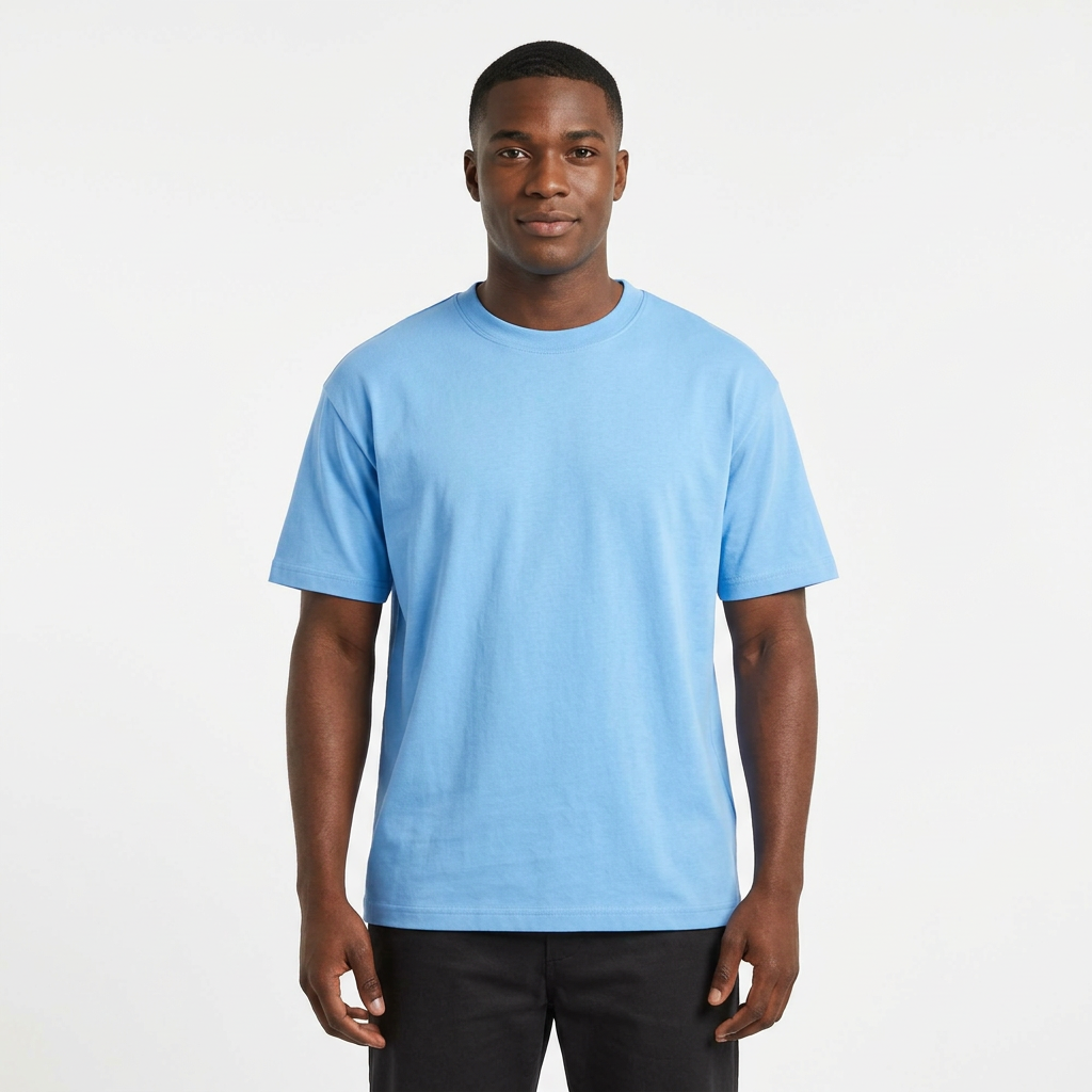 Nigerian male model wearing a sky-blue crew-neck T-shirt on white
