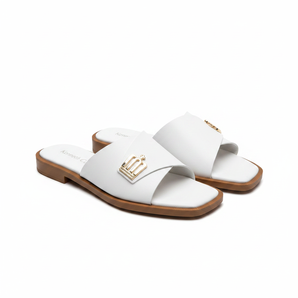 Pair of white leather wide strap flat slide slippers with gold logo hardware on white background