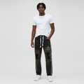 African Gen Z male model wearing men's black washed ripped wide-leg denim jeans with gold side stripe