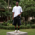 Nigerian male model wearing men's black tribal flame embroidered hardware denim shorts streetwear style