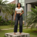 Nigerian female model wearing women's washed black high-waist wide-leg straight denim jeans, garden setting