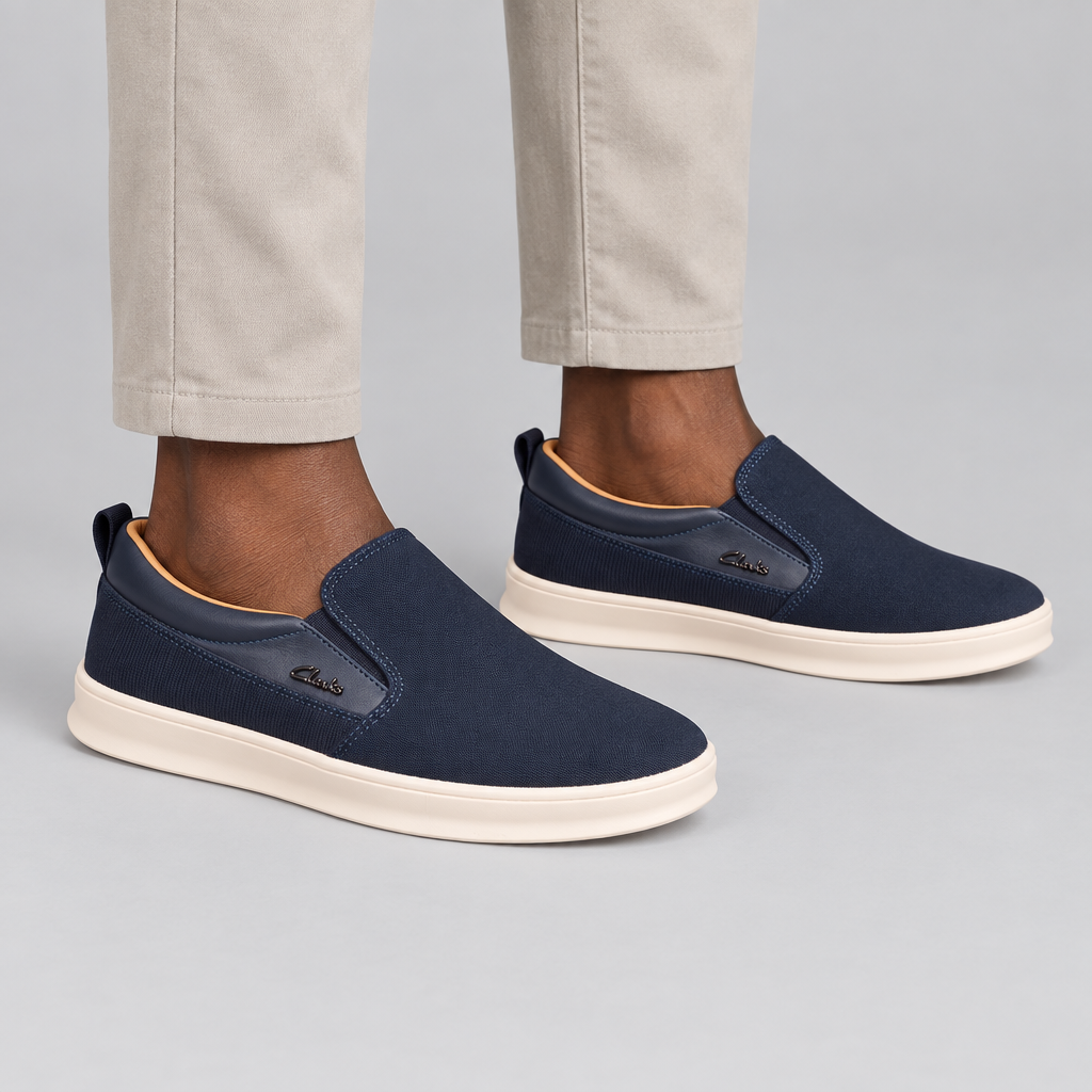Both navy cream-sole slip-on sneakers worn against a plain studio background
