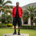 Nigerian male model wearing red equestrian emblem zip-up harrington jacket – full body lifestyle shot