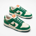 Pair of green and cream low-top sneakers with orange accents on white