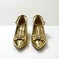 Matching gold jeweled-bow heels standing together side by side