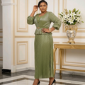 Nigerian woman wearing sage green and gold shimmer brocade peplum blouse and pleated midi skirt set
