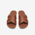 Pair of cognac brown textured cross-strap slides on white