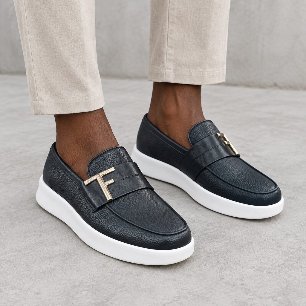 Men's black textured loafers with white soles worn on both feet