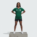 Nigerian female model wearing green Aztec graphic football jersey on concrete plinth