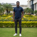 Nigerian male model wearing navy blue solid short sleeve polo shirt with white dotted stitch trim