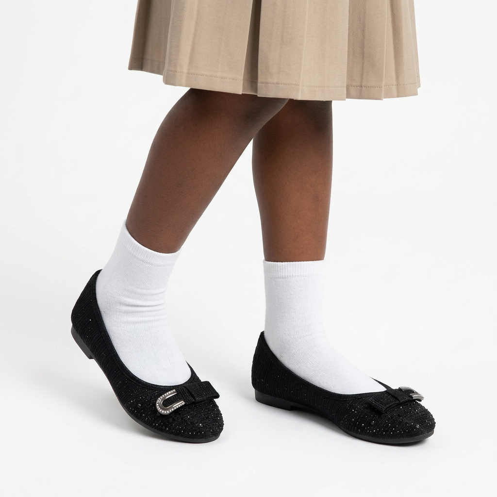 Girl wearing black textured bow ballet flats with white socks