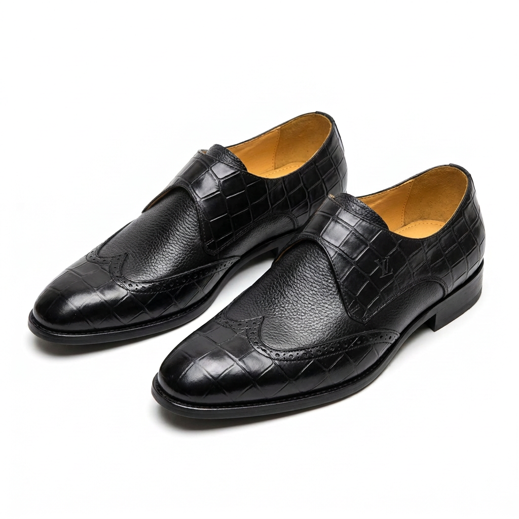 Pair of black croc-panel wingtip slip-on dress shoes on white