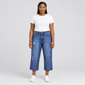Black woman wearing mid-blue distressed jeans, front view