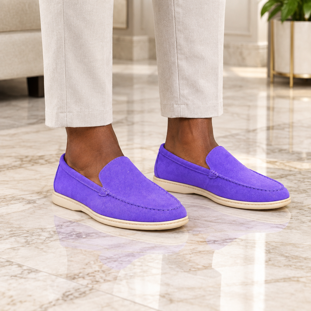 A Nigerian man wearing both purple suede loafers on a marble floor