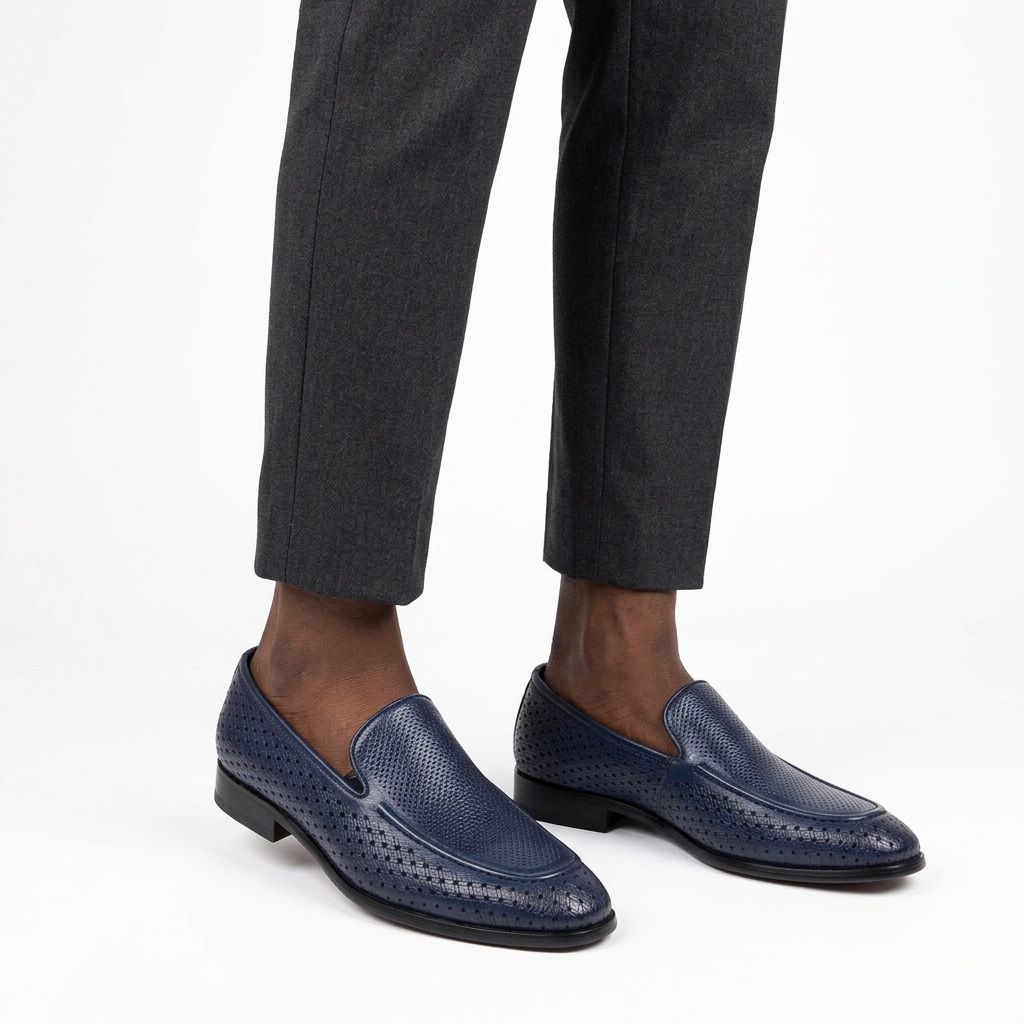 Navy perforated slip-on loafers worn on both feet