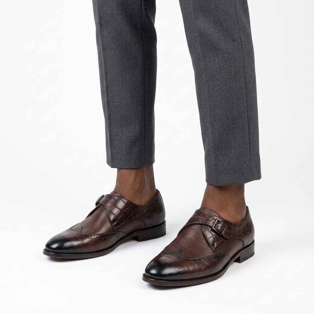 Both brown mixed-texture buckle shoes worn with charcoal trousers on white