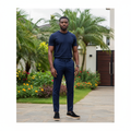 Nigerian male model wearing navy black suede slip-on sneakers with tri-layer sole in garden setting