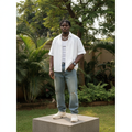Nigerian male model wearing white oversized short-sleeve button-down shirt – full body lifestyle shot