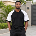Black Nigerian adult model wearing a black and white raglan short-sleeve shirt