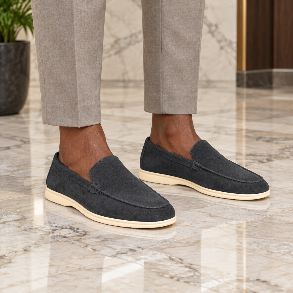 A Nigerian man wearing both black suede moc-stitch loafers on a marble floor