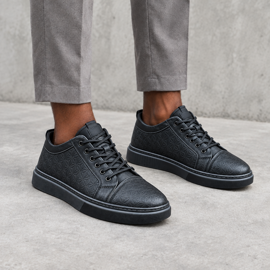Black geometric-embossed lace-up sneakers worn on both feet