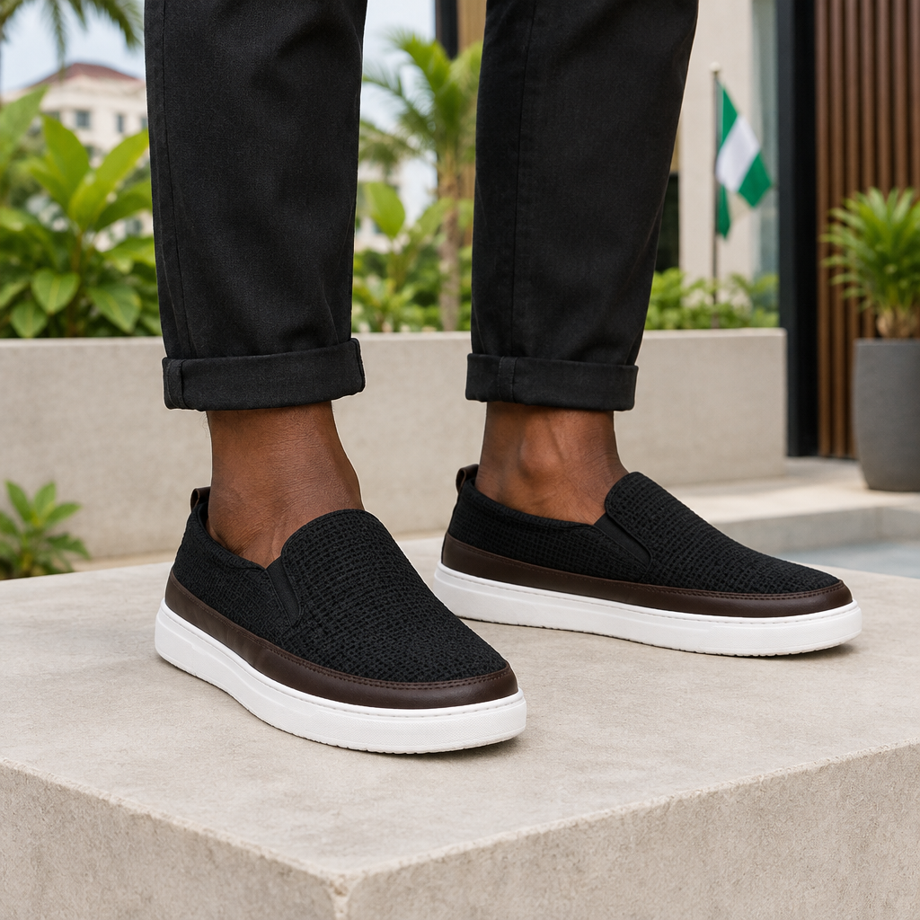 Man wearing black textured slip-on sneakers with rolled trousers
