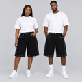 Woman and man together wearing longer black denim shorts with silver-tone stud trim