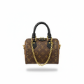 Tan monogram mini speedy bag with gold studs and yellow leather trim on white background