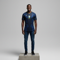 Nigerian male model wearing navy blue lightning graphic away football jersey on concrete plinth