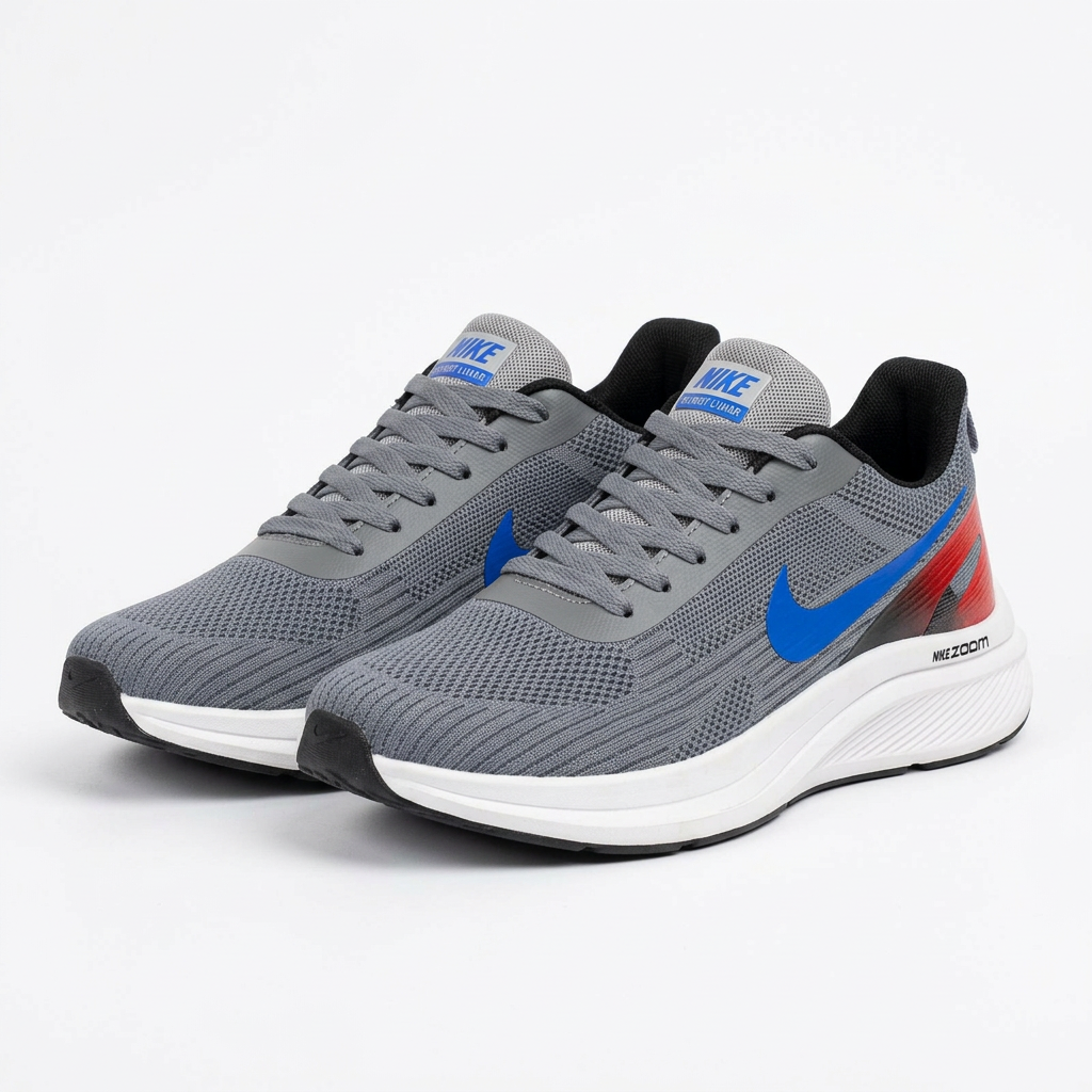 Pair of grey mesh sneakers with blue accents and white soles on plain white