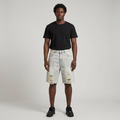 Full-body male model wearing light grey distressed denim shorts