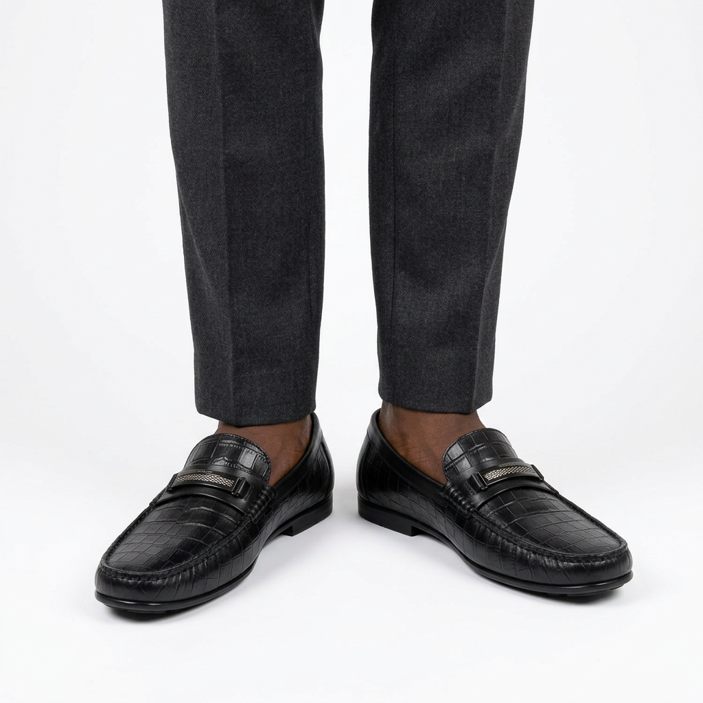 Black croc-effect loafers worn on both feet with charcoal trousers