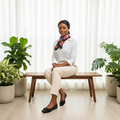 Nigerian female model seated wearing black croc-embossed patent ballet flats with strap buckle detail